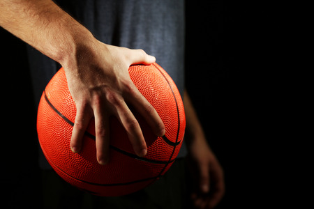 38075936 Basketball Player Holding Ball, On Dark Background