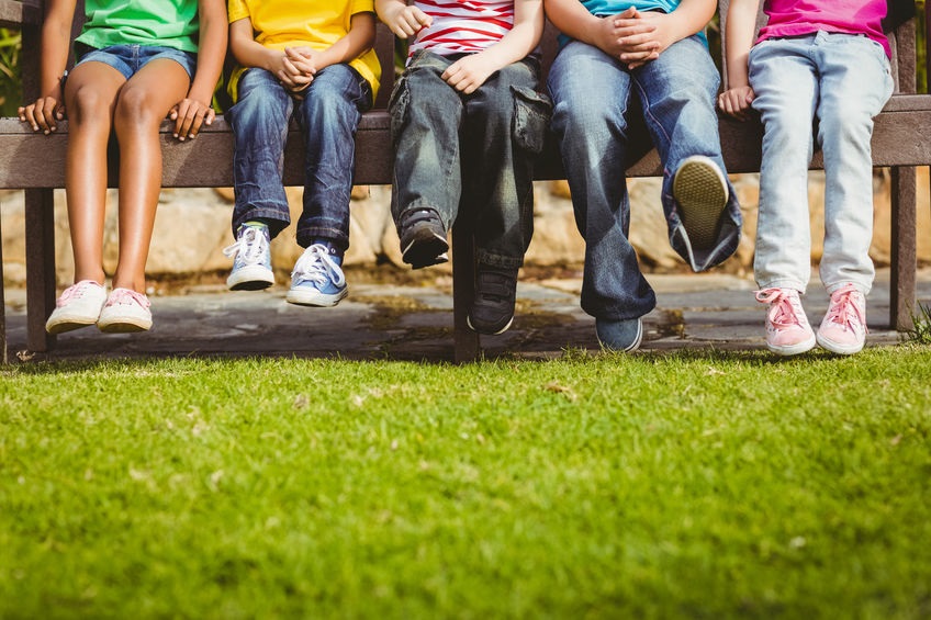 Close Up View Of Classmates Sitting On Bench On Campus